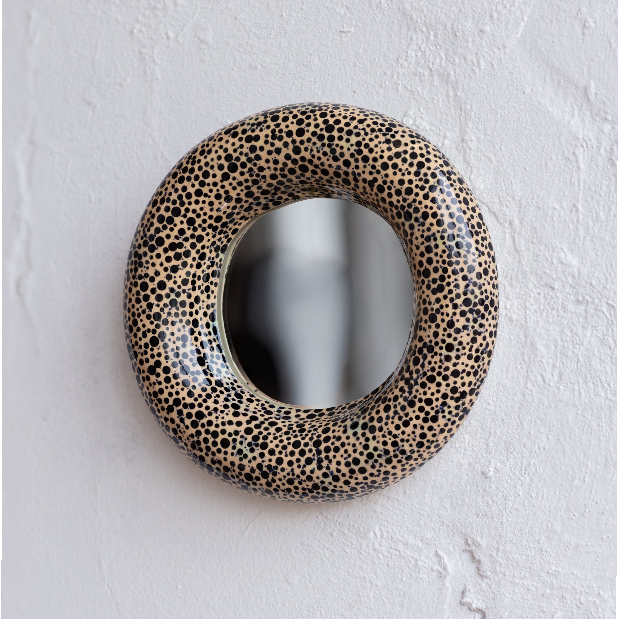 Round mirror with a spotted frame