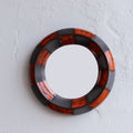 Round mirror with black and red circular design
